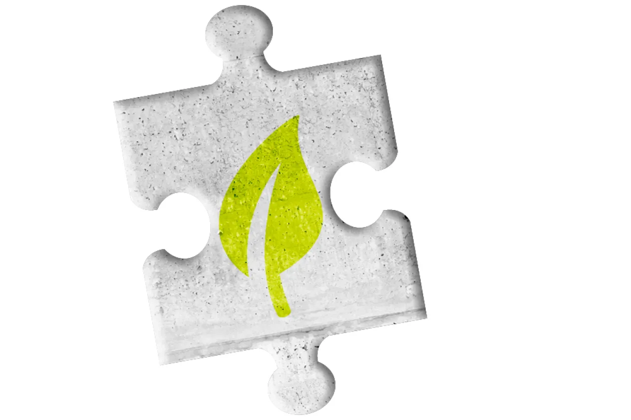 Grünes Blatt auf grauem Puzzleteil