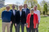 Gruppenbild: fünf Männer und eine Frau stehen auf einer Wiese