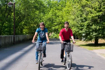 Studierende die Fahrrad auf dem Campus fahren